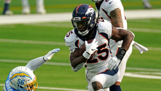 Denver Broncos running back Melvin Gordon (25) runs the ball as Los Angeles Chargers outside linebacker Kenneth Murray (56) attempts to make the tackle during the first half at SoFi Stadium.